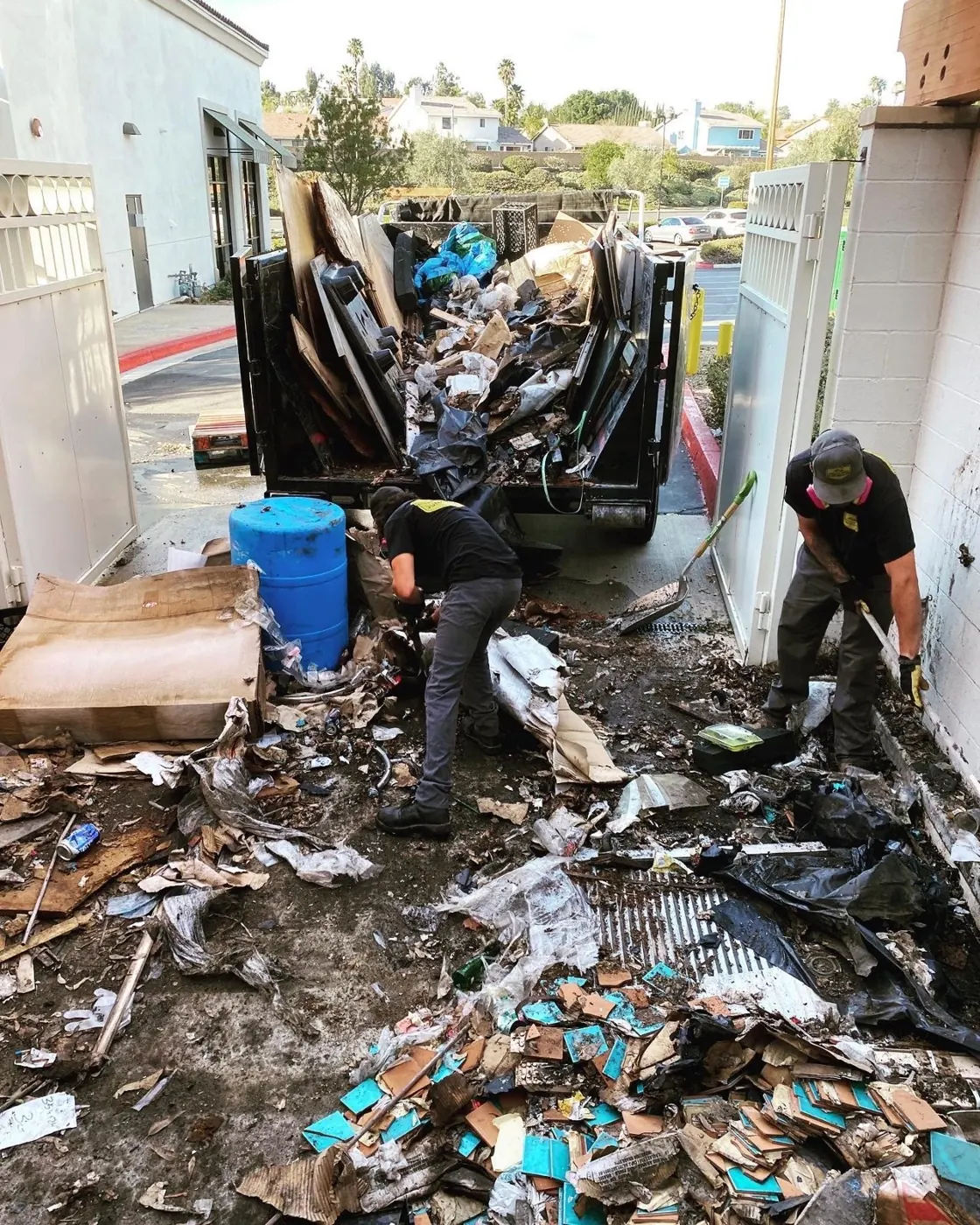Crew clearing debris from a narrow side yard