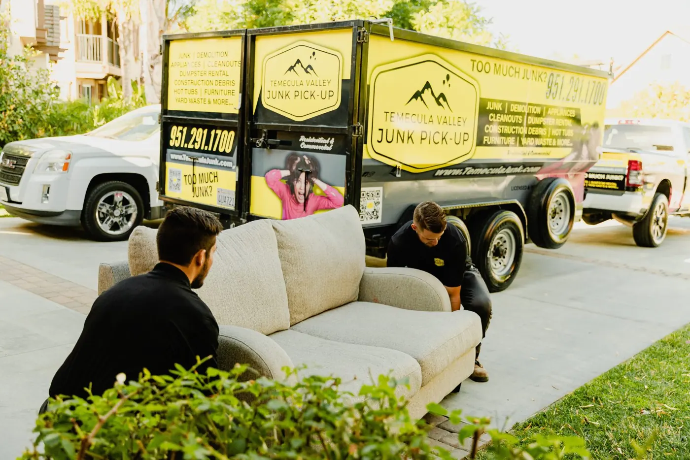 Team loading a couch into the Temecula Valley Junk Pick-Up trailer