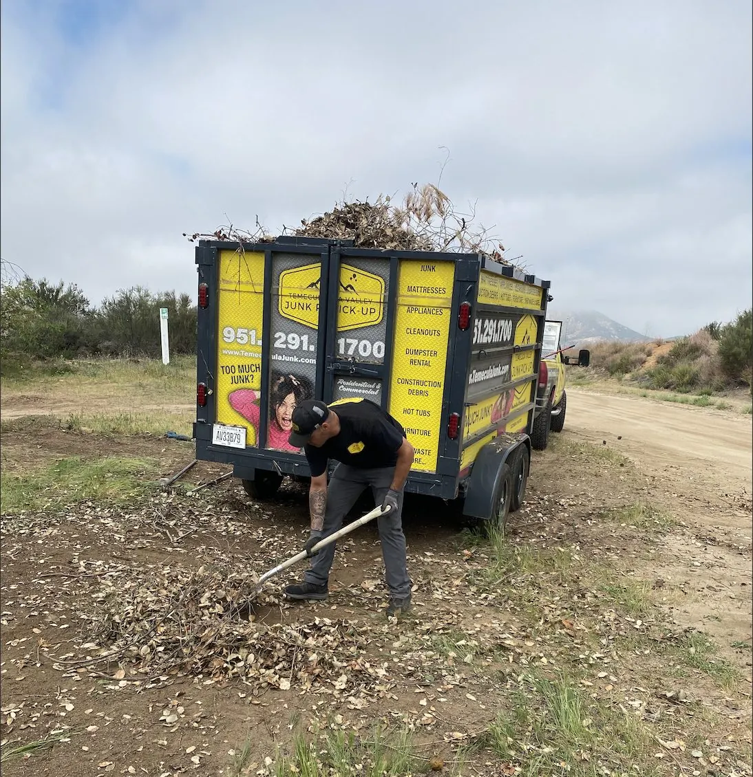 Crew raking up yard debris on a lot