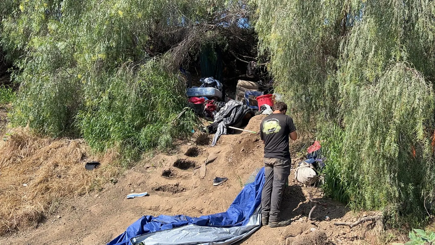 Team clearing an encampment on a hillside