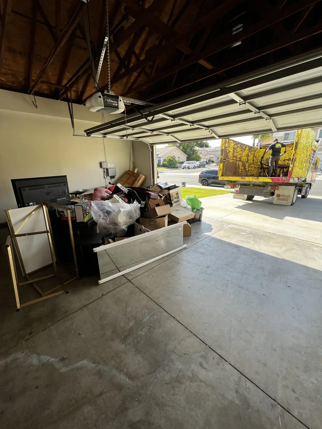 Garage cleanout in progress with the trailer in the driveway